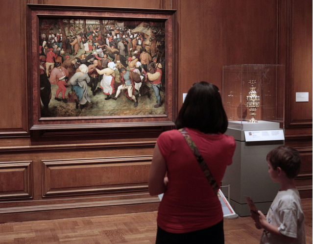 A visitor in front of Breughel's The Wedding Dance at the Detroit Museum.