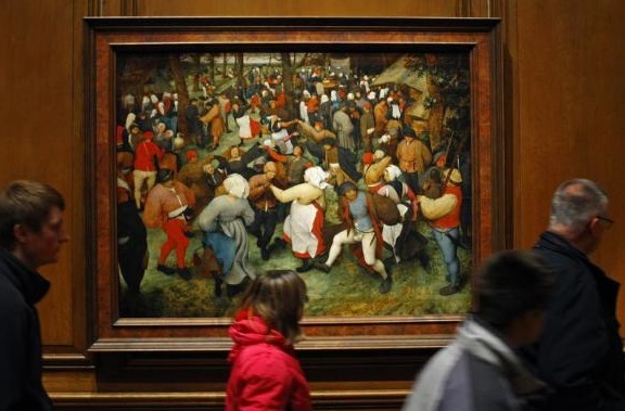 Visitors walking past 'The Wedding Dance' by Peter Breughel the Elder in the Detroit Institute of Arts